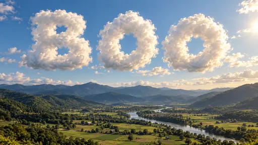 The word BOO spelled in three huge letters of white cumulus cloud floating in a blue sky above a green river valley with farm fields, forested hills, blue mountain ridges and a low sun at the upper right.