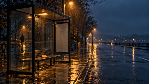 A cinematic night photograph: an empty glass-and-steel bus shelter stands at the left third beside a rain-soaked street. On its bench lies one small pale-orange paper slip cut as a round pumpkin with a tiny stem. In the glass reflection alone stands one small dark silhouette; the real street is empty. Amber streetlight pools on the bench and wet pavement, the rest falls into blue-grey rain — the upper right sky stays simple as clear copy space. An eerie Halloween background.