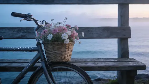 A misty coastal morning scene with a wooden bench overlooking the calm sea, a bicycle with a flower-filled basket leaning nearby, cool blue tones and soft dawn light.