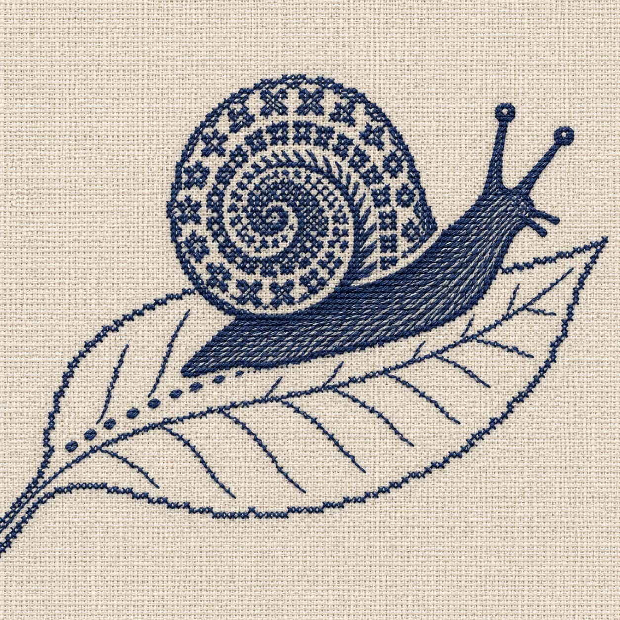 A snail on a leaf stitched in dark indigo thread on cream linen, spiral shell of denser stitches, two eyestalks, a trail of small stitches along the leaf vein.