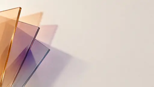 A fan of overlapping translucent glass sheets enters from the lower left corner throwing muted apricot and smoky lilac shadows across a blank ivory wall that fade before the centre, except at one small deep violet patch where three shadows cross and mix.