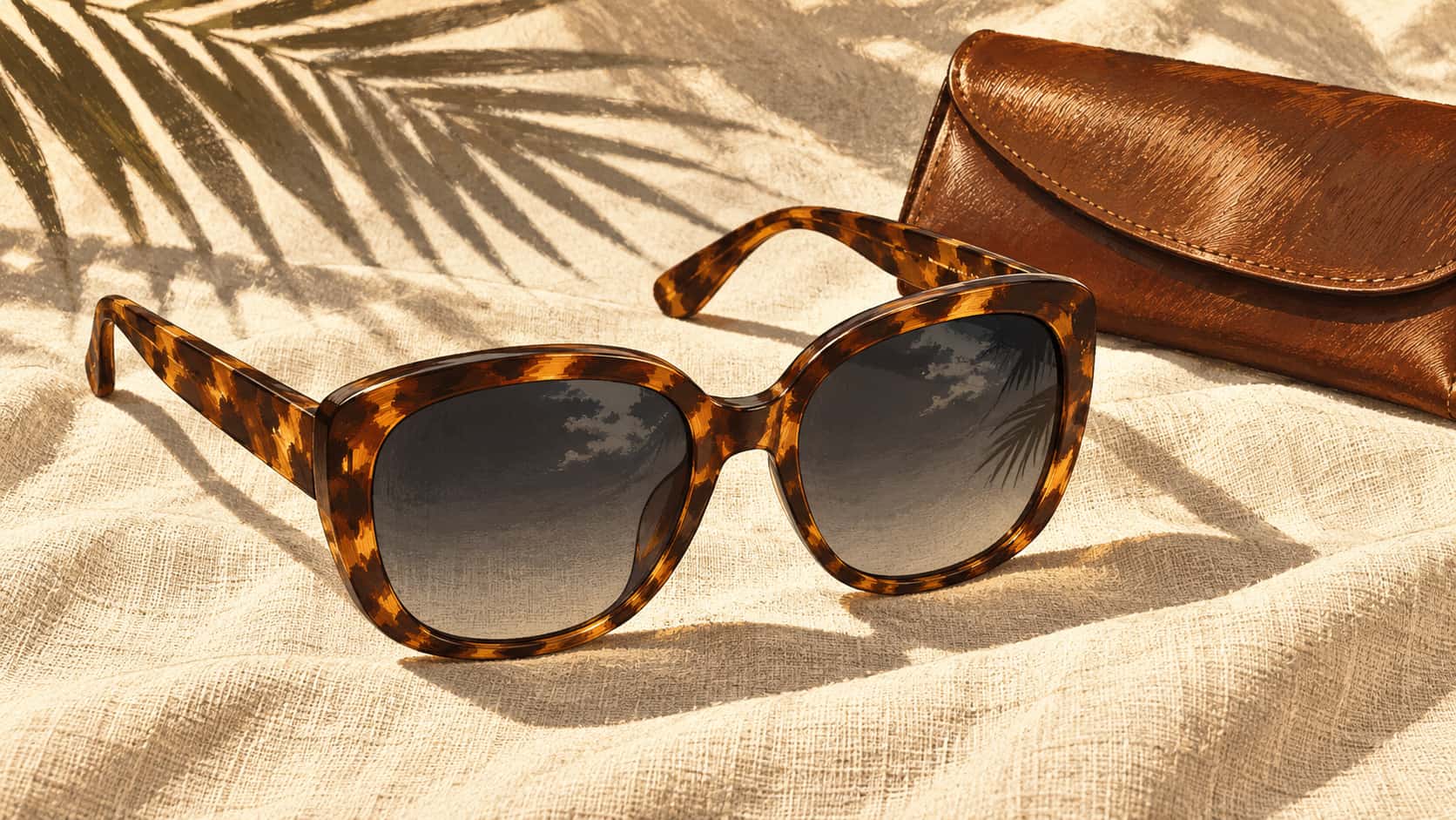 Plain oversized tortoiseshell sunglasses with dark gradient lenses lie unfolded on pale linen beside a small leather case in a comic tone illustration with scraped highlights.