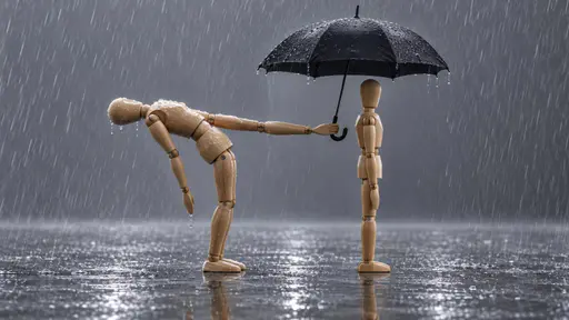 Bending over backward: a full side view sculptural scene photograph under soft rainy light, where a wooden artist's mannequin arches deeply backward from the waist to hold an open black umbrella squarely over a second upright mannequin, its own bent body left outside the canopy in the falling rain.