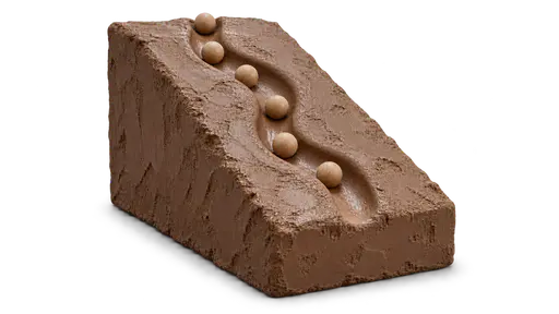 Practice carves a riverbed: A tilted clay slope where dozens of identical wooden balls have worn one smooth winding channel from top to base; the newest ball sits in the groove with five more following. Repetition creates an easier, more reliable route.
