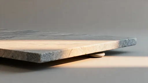 A minimal, close-cropped stone surface rendered as a smooth gradient across a 16:9 frame, emphasizing tactile grain and subtle tonal shifts for calm, modern backgrounds and material studies.