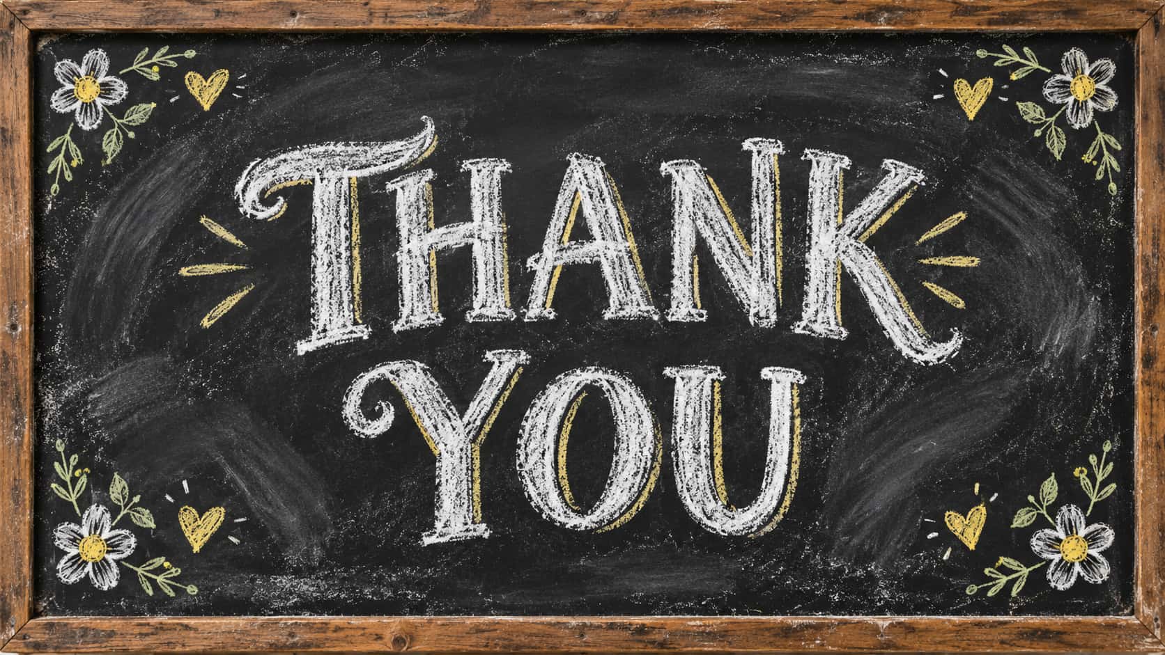 The words THANK above YOU in hand-drawn white chalk capital letters with yellow chalk shadows on a black chalkboard in a worn wooden frame, with small chalk daisies, hearts and leaves in the corners.